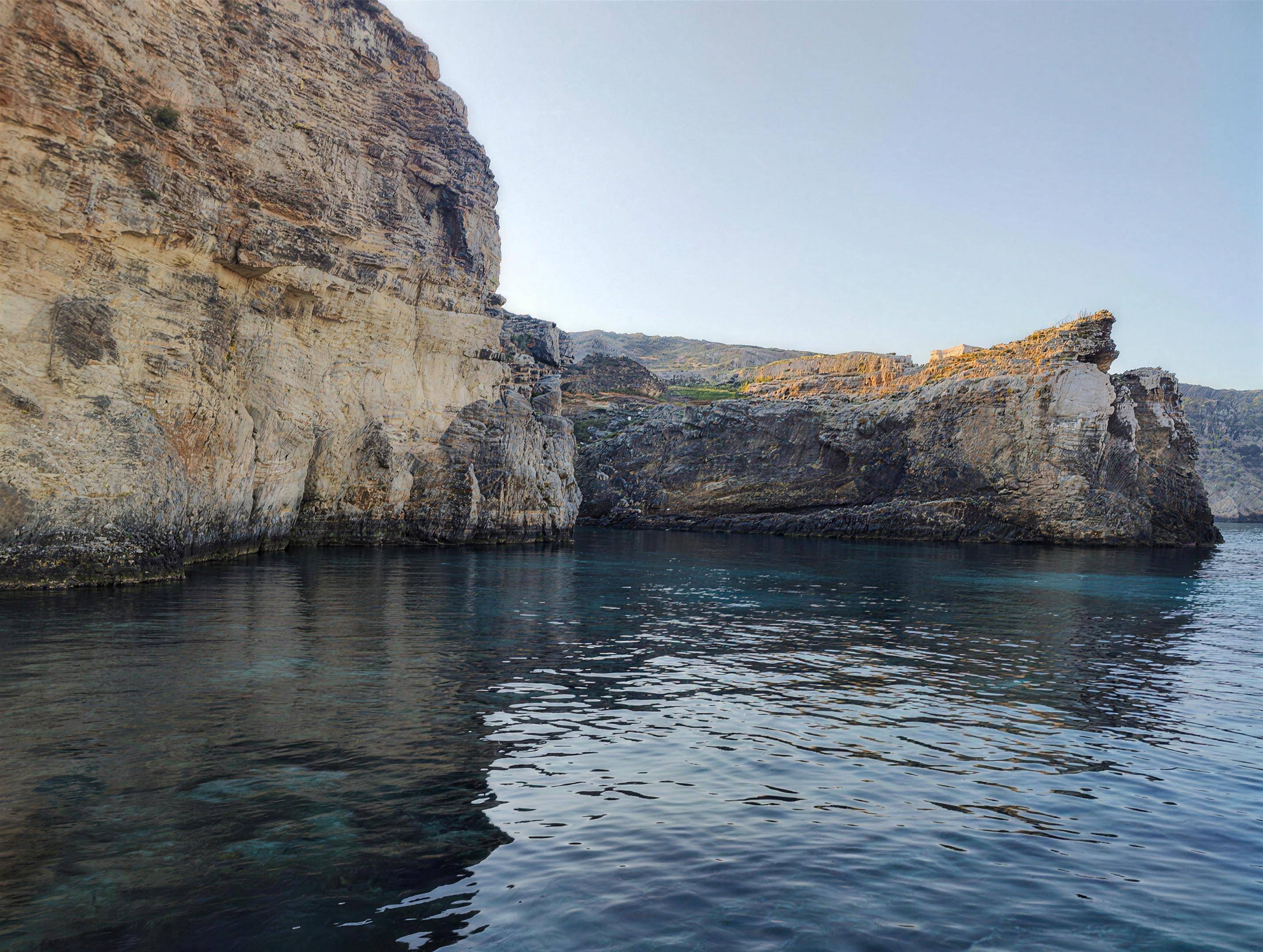 Limestone cliffs dropping into still water